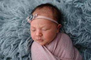 Portrait of a sleeping newborn baby in blue fur photo