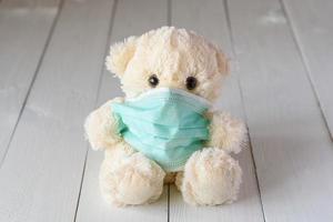 oso de peluche para niños con una máscara médica foto