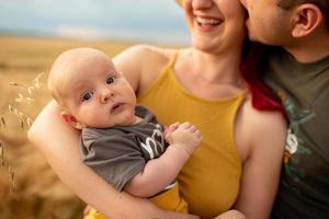 Father, mother and their little son have fun together in a wheat field. photo