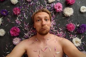 Guy takes selfie in flowers photo