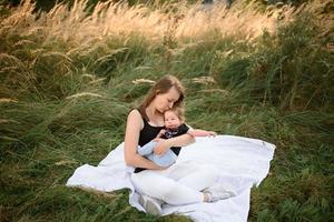 Mom and baby cuddle on a plaid photo