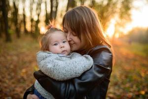 Young mother and her toddler girl in autumn fields photo