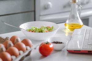 Online cooking. Preparing salad using digital cookbook. photo