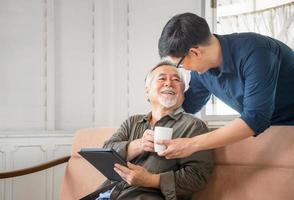 Cheerful senior asian father and middle aged son in living room, Happiness Asian family concepts photo