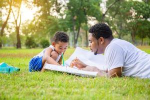 alegre padre afroamericano e hijo jugando en el parque, padres e hijos dibujando y pintando en el parque, conceptos familiares de felicidad