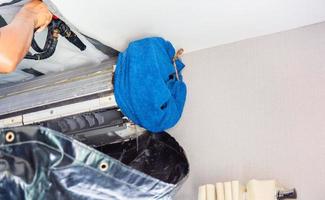 Close up of Air Conditioning Repair, repairman cleaning a room air conditioner system photo