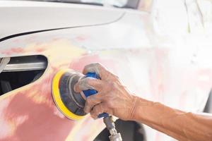 Close up of A repairman sanding with a grinder and prepares the paint for the car, Car repair concept photo