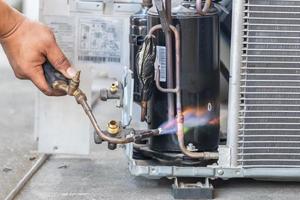 Close up of Air Conditioning Repair use fuel gases and oxygen to weld or cut metals, Oxy-fuel welding and oxy-fuel cutting processes, repairman on the floor fixing air conditioning system photo