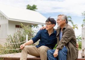 Senior asian father and middle aged son sitting relax together outdoors, Happiness Asian family concepts