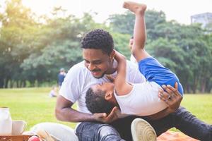 Cheerful african american father and son having a picnic in the park, Happiness family concepts photo