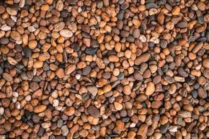 Brown sea pebbles natural background, Small rock or stone texture floor in decorative a garden. photo