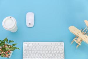 vista superior con espacio para copiar el teclado de la computadora y la taza de café sobre fondo azul pastel, concepto plano foto