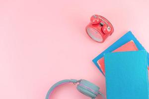 Top view with copy space of books, red clock and headphones overhead on pink pastel background, Flat lay and relaxing concept photo