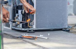 Close up of Air Conditioning Repair team use fuel gases and oxygen to weld or cut metals, Oxy-fuel welding and oxy-fuel cutting processes, repairman on the floor fixing air conditioning system photo