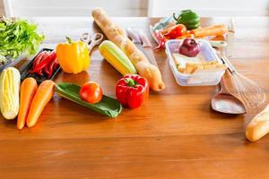 pimiento rojo, pan y verduras para cocinar en una mesa de madera con espacio para copiar foto