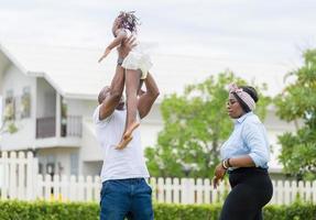 Happy father mother and daughter playing together outdoor, Cheerful african american family enjoying in the park, Happiness family concepts photo