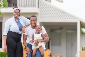 alegre familia afroamericana con equipaje en un nuevo hogar, conceptos familiares de felicidad foto