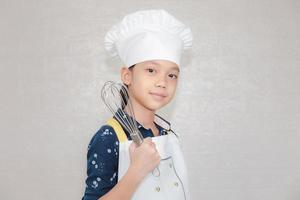 concepto de carreras de ensueño, retrato de niño feliz chef mirando la cámara con fondo borroso foto