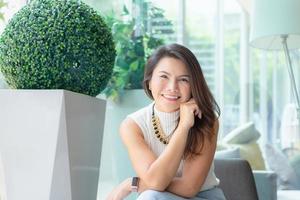Happy successful confident smart young asian business woman sitting relax and smiling in office. photo