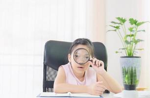 Cheerful little smiling girl with a magnifying glass, Education and learn from home concept photo