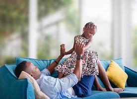 Cheerful african american father and daughter playing in living room, Happiness family concepts photo