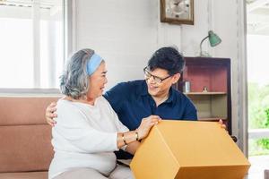 Senior asian mother and middle aged son sitting relax in living room on moving day, Happiness Asian family concepts photo