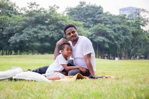 Cheerful african american father and son playing in park, Happiness family concepts, parent and childs play in park photo