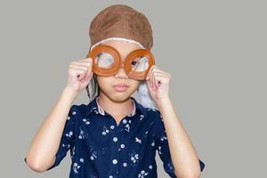 niño piloto aviador con trazado de recorte sobre fondo gris, niño feliz jugando concepto foto