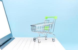 Shopping cart on white laptop pc with light blue background, Online shopping concepts
