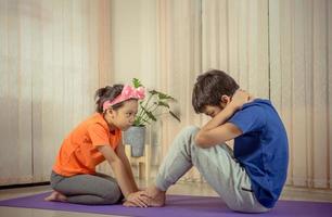 feliz hermano e hija haciendo ejercicios de estiramiento en casa, niños jugando concepto foto