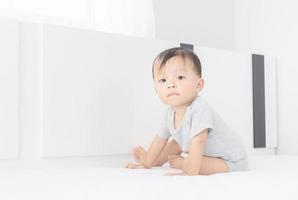 retrato de un niño pequeño que se arrastra en la cama, niños jugando y concepto de felicidad foto