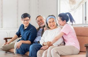 felicidad concepto de familia asiática, madre mayor padre e hijo e hija de mediana edad en la sala de estar foto