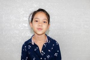 Portrait of Happy little girl kid smiling and looking at camera with blurred background photo