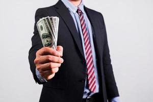 Businessman in suit holding several 100 dollar bills. Finance concept. photo