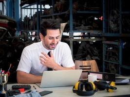 gerente de repuestos automotrices del almacén que tiene videoconferencia por computadora con el cliente. reunión de empresarios a través de videoconferencias en línea por computadora portátil. foto