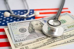 Black stethoscope with US dollar banknotes on USA America flag background, Business and finance concept. photo