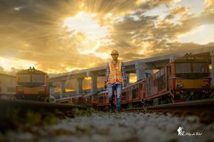 ingeniero ferroviario bajo control del proceso de construcción prueba de trenes y control del trabajo ferroviario en la estación de ferrocarril con comunicación por radio. ingeniero con uniforme de seguridad y casco de seguridad en el trabajo. foto