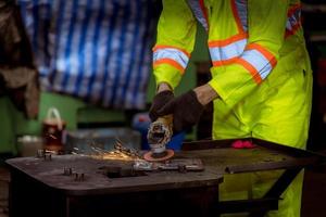 ingeniería industrial y trabajo en equipo con control uniforme de seguridad que opera la máquina rectificadora de torno que trabaja en la fábrica de la industria. foto