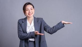 Portrait of a beautiful Asian businesswoman on a gray background photo