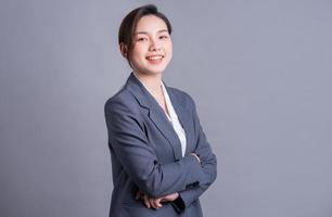 Portrait of a beautiful Asian businesswoman on a gray background photo