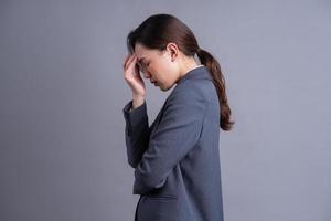 Portrait of a beautiful Asian businesswoman on a gray background photo