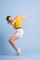 Full length image of young Asian woman posing on blue background photo