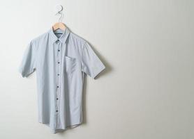 hanging shirt with wood hanger on wall photo