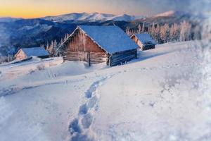 chalets en las montañas al atardecer. saludos de invierno foto