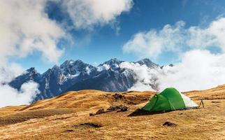 Tent against the backdrop of snow-capped mountain peaks. photo