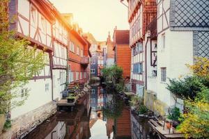 Narrow streets with buildings on two sides and water between the photo