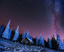 cabaña en las montañas. Fantástica lluvia de meteoritos de invierno y nieve. cárpatos ucrania europa foto