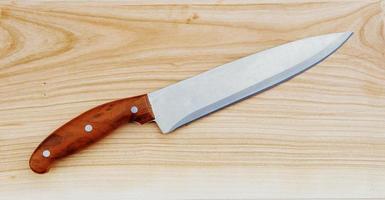cuchillo en una tabla de cortar de madera foto