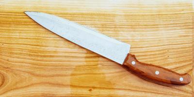 knife on an wooden cutting board photo