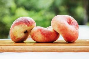 flat peaches on wood table photo